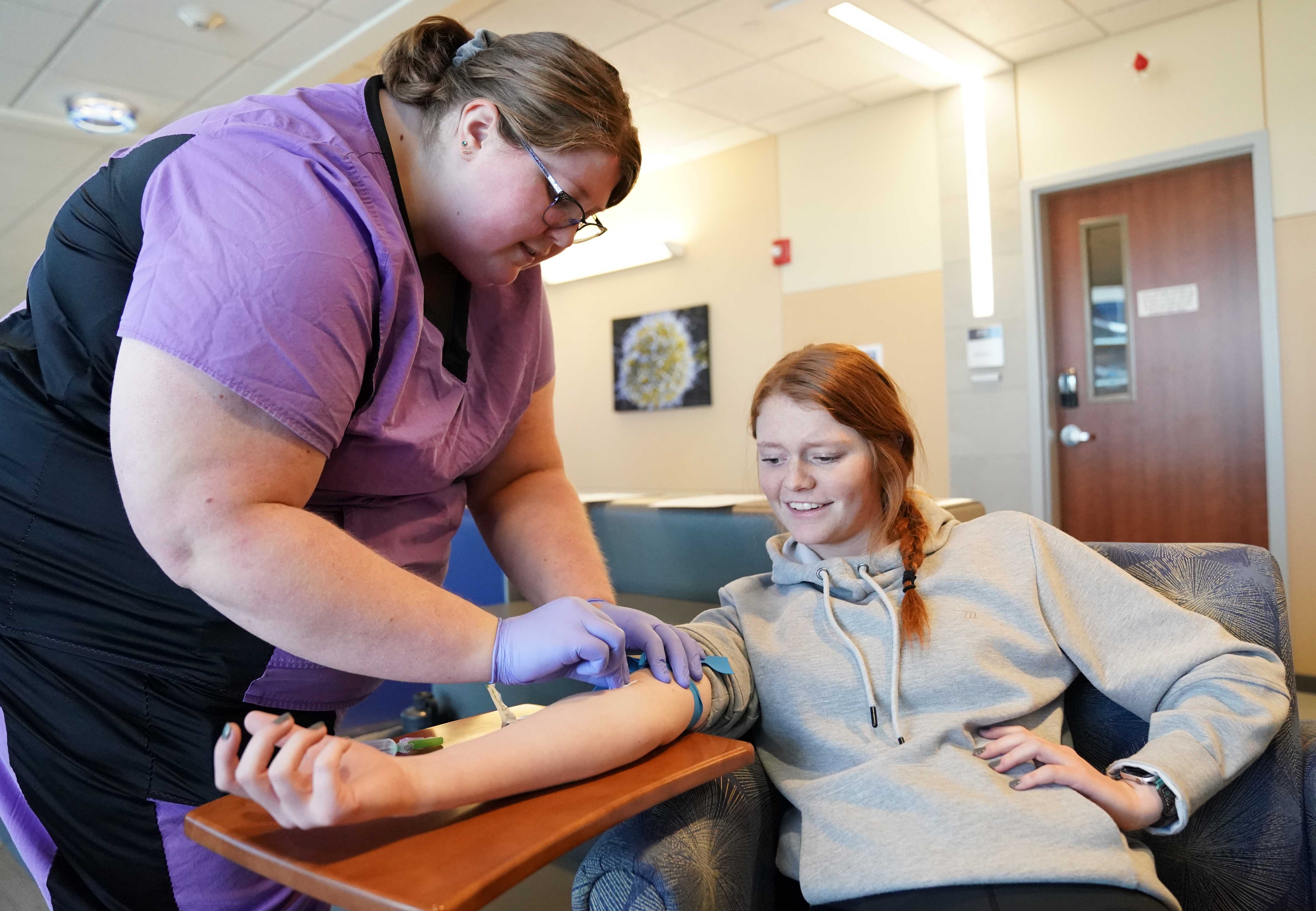 MLT student Mariah Schneider performs a blood draw on Kylie Licking.