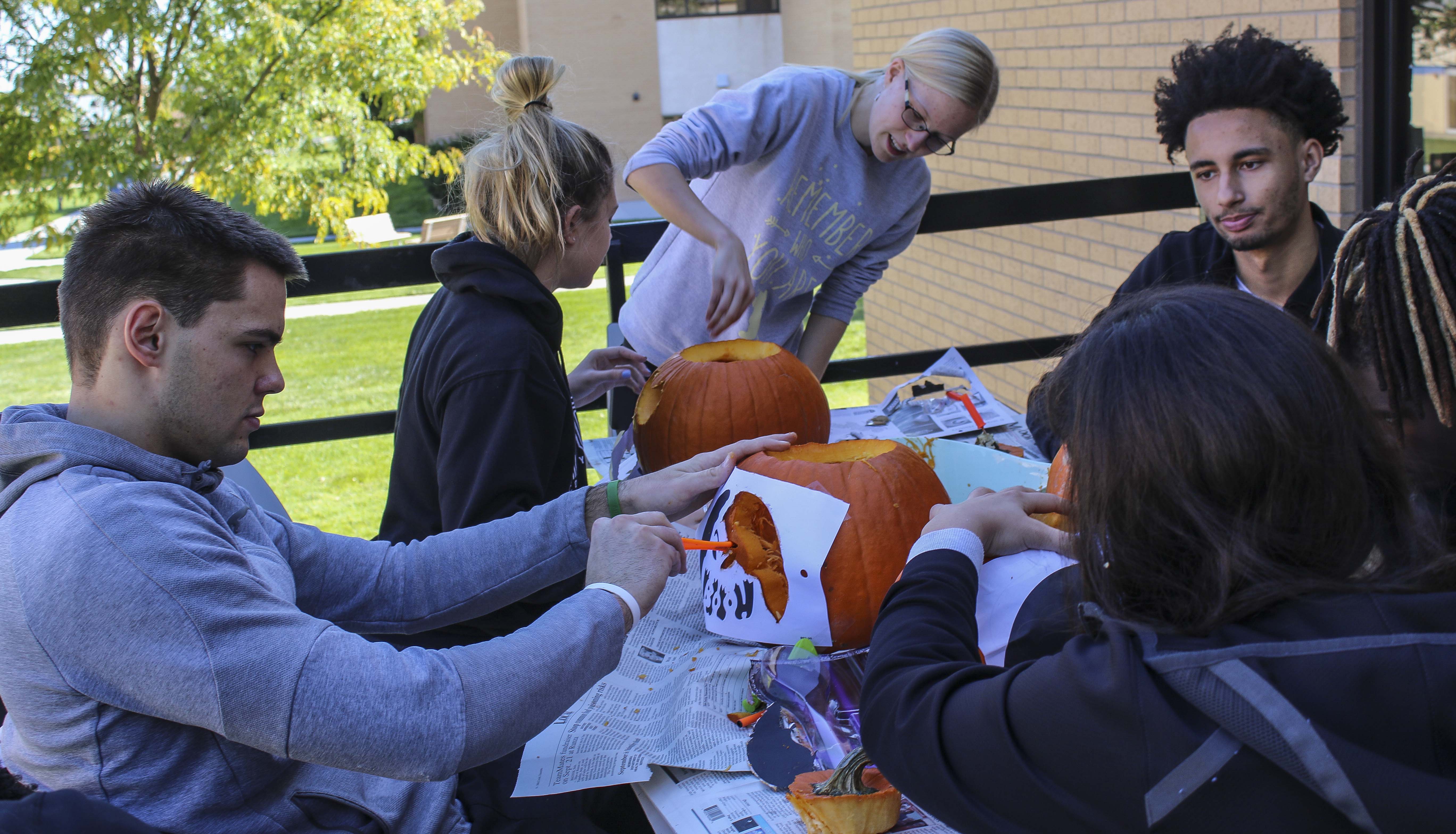 MCC International Club members carve pumpkins