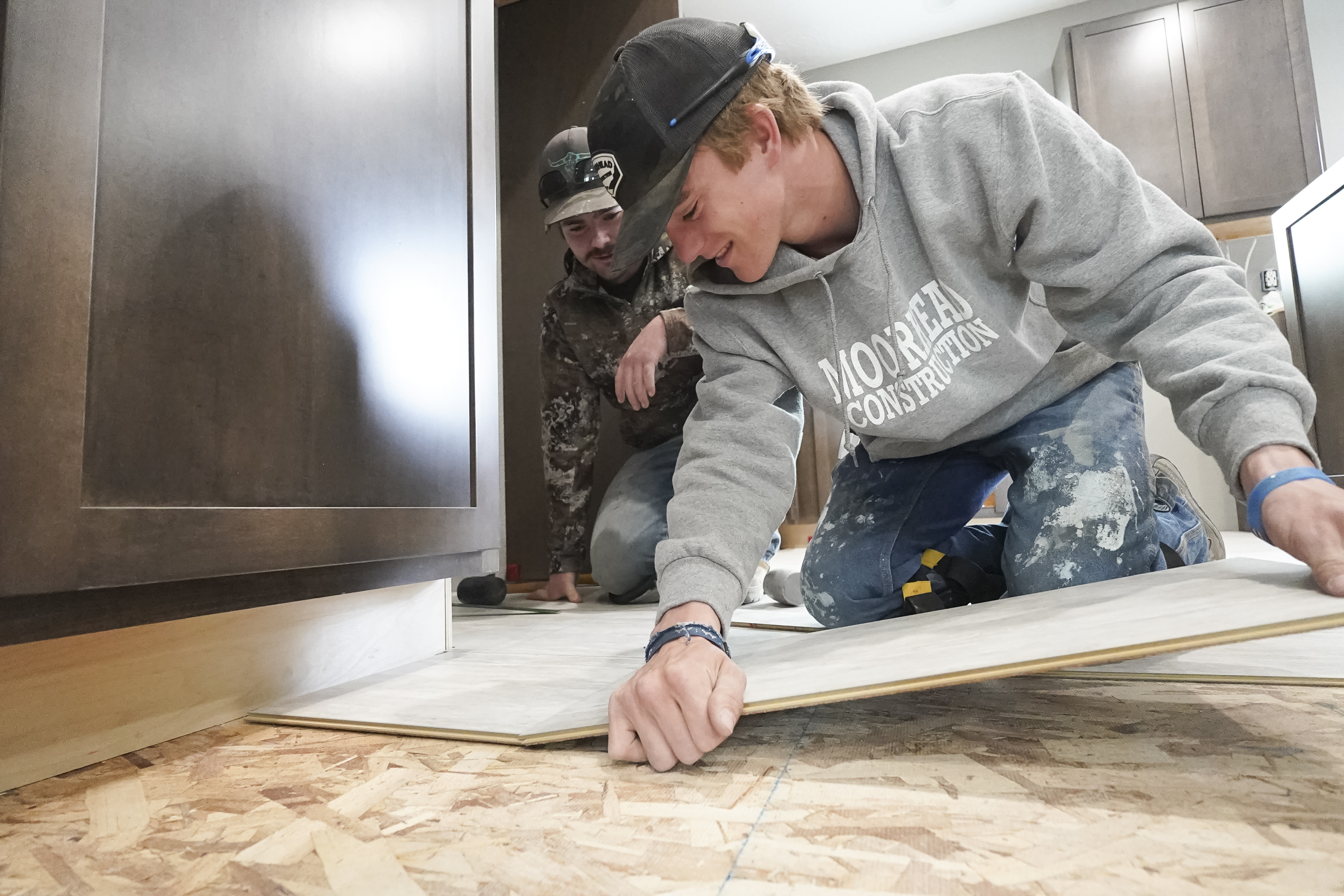 Chase Moorhead, of Hershey, and Tallin Schauda, of Broken Bow, install kitchen tile in the project house. 