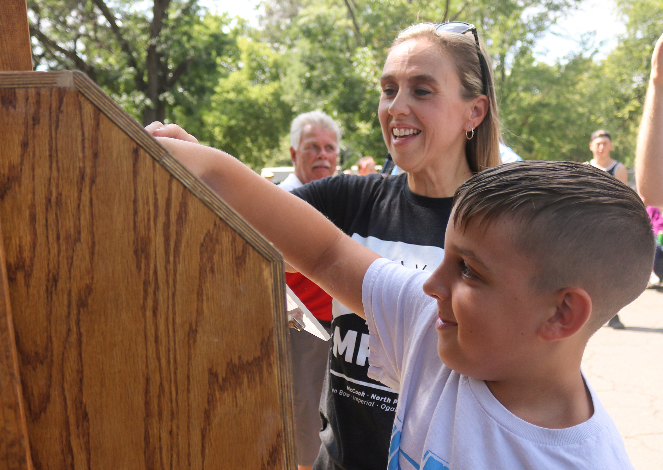 Konnor Knapp assists Dr. Jody Tomanek, vice president of academic affairs and North Platte Community College, with drawing the winning ticket for the 1972 Pontiac Le Mans Sport at the Colonel Cody’s Cruise Show and Shine in Memorial Park on Saturday.