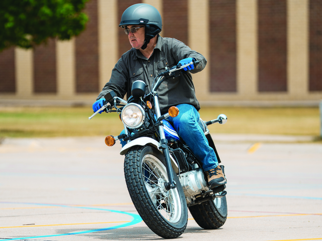 A man riding a motorcycle during a motorcycle training course on NPCC's North Campus